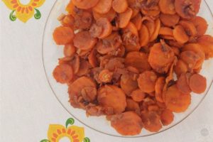 Sauteed Carrots On A Serving Pate On A Decorative Cloth With Flowers.