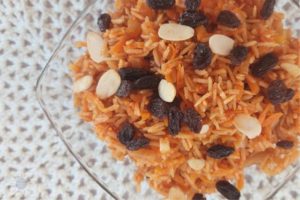 Wholegrain Rice And Carrots In Square Glass Dish On Top Of Lace Placemat.