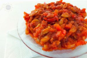 Zucchini, Bell Peppers And Tomato Sauce on A Serving Plate With A Folded Napkin On The Side.