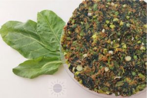 Spinach Frittata On A Serving Plate With Decorative Spinach Leaves On The Side.