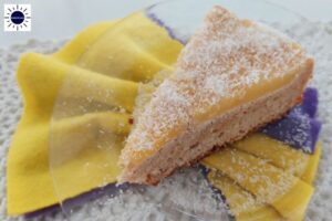 Gluten-Free Pineapple Coconut Cake Slice On A Glass Plate Resting On An Accordion Folded Napkin Below.
