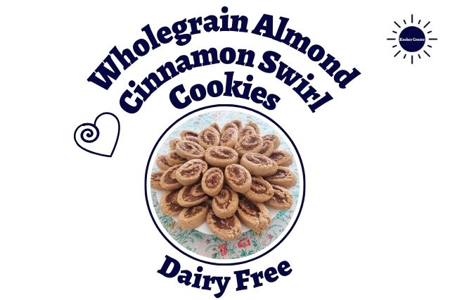 Wholegrain Almond Cinnamon Swirl Cookies Arranged Like A Flower On A Serving Plate On Top Of A Flowered Tablecloth In A Decorative Circle With The Inscription Dairy Free Below And With A Swirled Heart On The Side.