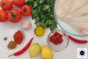 The Baked Mediterranean Tomatoey Spicy Fish Ingredients Spread Out On A Table With The Fish, Tomato Paste Olive Oil and Spices In Glass Dishes And With The Kosher Create Sun Logo In The Lower Left Corner.
