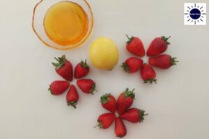 Strawberry Filling Ingredients On A Table With The Strawberries Designed into Flowers And The Honey In A Glass Bowl With The Kosher Create Sun Logo In The Upper Right Corner.. .