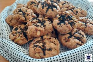Wholegrain Vegan Onion Soda Bread Rolls Arranged In A Circular Fashion On A Silky Polka Dot Cloth With The Kosher Create Sun Logo In The Lower Right Corner.