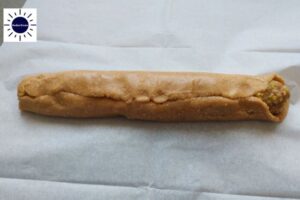 The Upper Part Of The Dough Folded Toward The Middle Of The Filling With The Kosher Create Sun Logo In The Upper Left Corner.