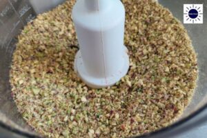 Pistachio Nuts Coarsely Blended In A Food Processor With The Kosher Create Sun Logo In The Upper Right Corner.