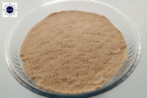 A Closeup Of Baked Pie Crust In A Round Glass Pie Dish With The Kosher Create Sun Logo In The Upper Left Corner.