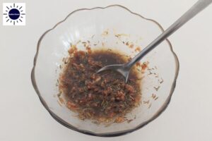 A Closeup Of The Dressing Mixture In A Glass Bowl With A Spoon And With The Kosher Create Sun Logo In The Upper Left Corner.