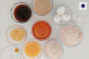 Mediterranean Wholegrain Orange Honey Cake Ingredients In Glass Bowls Arranged In A Circle With The Kosher Create Sun Logo In The Upper Right Corner.