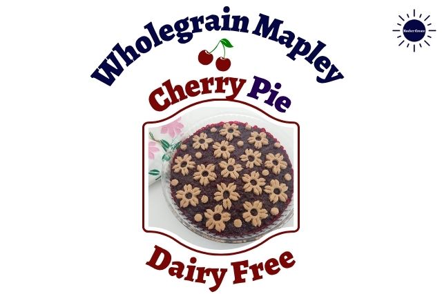 Wholegrain Mapley Cherry Pie In A Round Glass Baking Dish Decorated With A Delicate Cherry Blossom Cut Cookies Motif With A Decorative Napkin Folded In The Upper Left Side Adorned With Two Flowers Within A Decorative Frame With A Double Cherry Graphic Within The Title And With The Kosher Create Sun Logo In The Upper Right Corner.