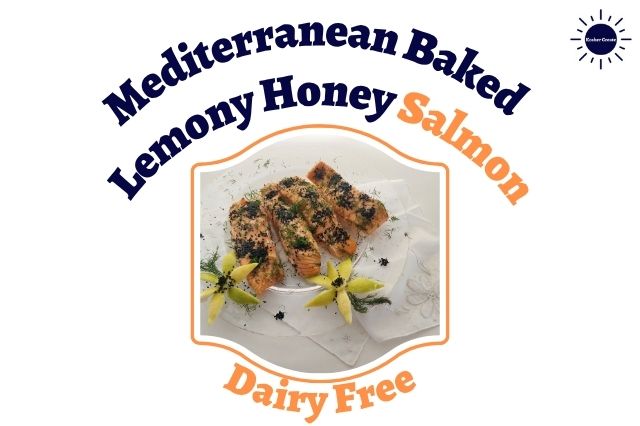 Mediterranean Baked Lemony Honey Salmon On A Round Glass Serving Dish Adorned With Diced Fresh Dill And With Nigella seeds And With Two Decorative Flowers Carved From Lemon Peels In The Front On Top Of A Decorative Cloth Within A Decorative Frame And With The Inscription Dairy Free Below And With The Kosher Create Sun Logo In The Upper Right Corner.