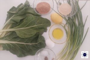 A Closeup Of Mediterranean Wholegrain Lemony Chard Balls Arranged On A Surface And In Glass Bowls With The Kosher Create Sun Logo In The Right Lower Corner.