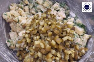 A Closeup Of The Pickles Added To The Salad With The Kosher Create Sun Logo In The Upper Right Corner.