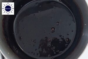 The Dairy-Free Maple Cocoa Glaze Simmering In A Pot With The Kosher Create sun Logo In The Upper Left Corner.