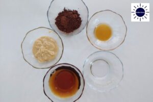 Dairy-Free Maple Cocoa Glaze Ingredients Arranged In Glass Bowls With The Kosher Create Sun Logo In The Upper Right Corner.
