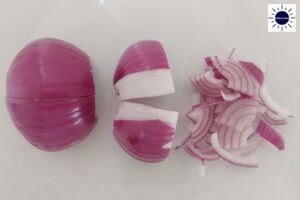A Closeup Of A Peeled Onion Slicing Process With The Kosher Create Sun Logo In The Upper Right Corner.