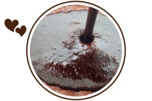 Cocoa Honey Glaze Pouring Onto A Cake Surface That's Suited For Dessert In A Decorative Circle Adorned With Two Graphic Hearts On The Side.